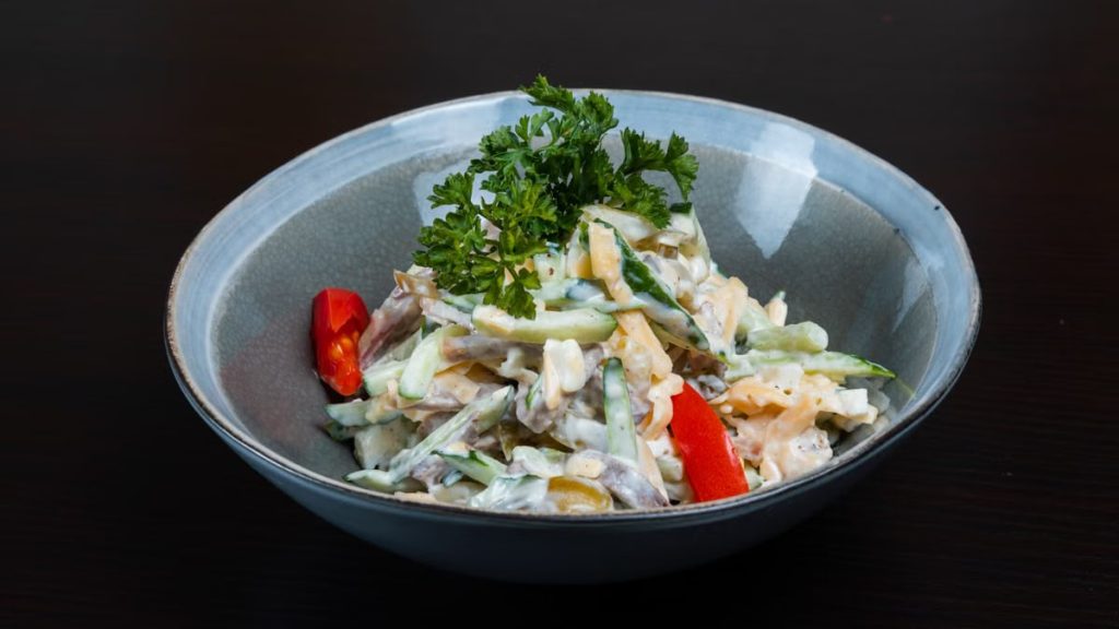 A fresh and colorful vegetable salad in a bowl with creamy dressing, perfect for healthy eating.